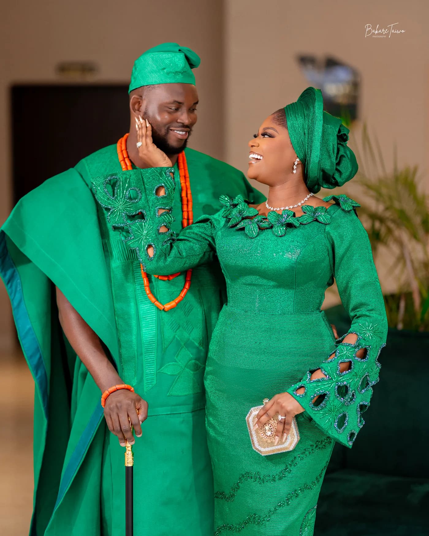 A couple in coordinated green traditional wedding attire.