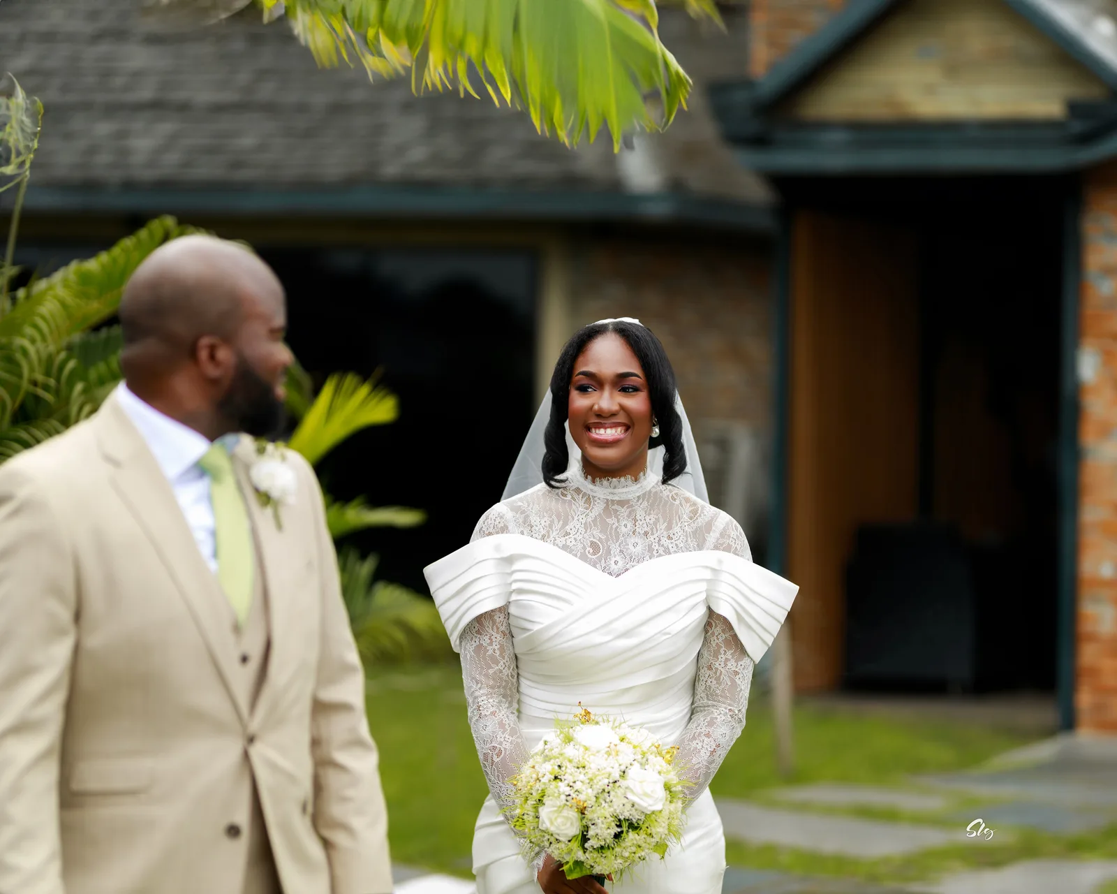 A bride holds a bouquet beside her partner.
